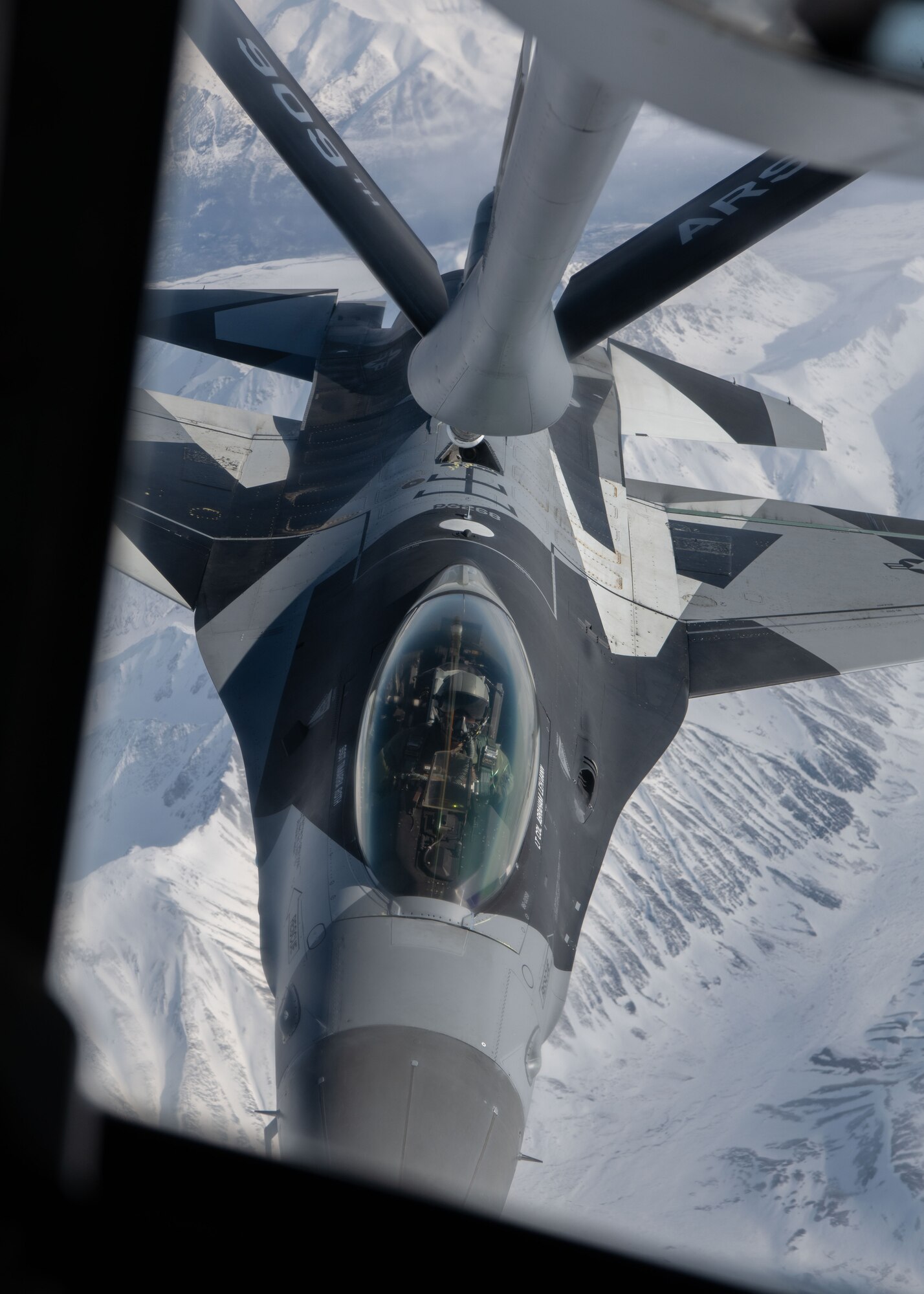 A photo of a plane refueling while flying