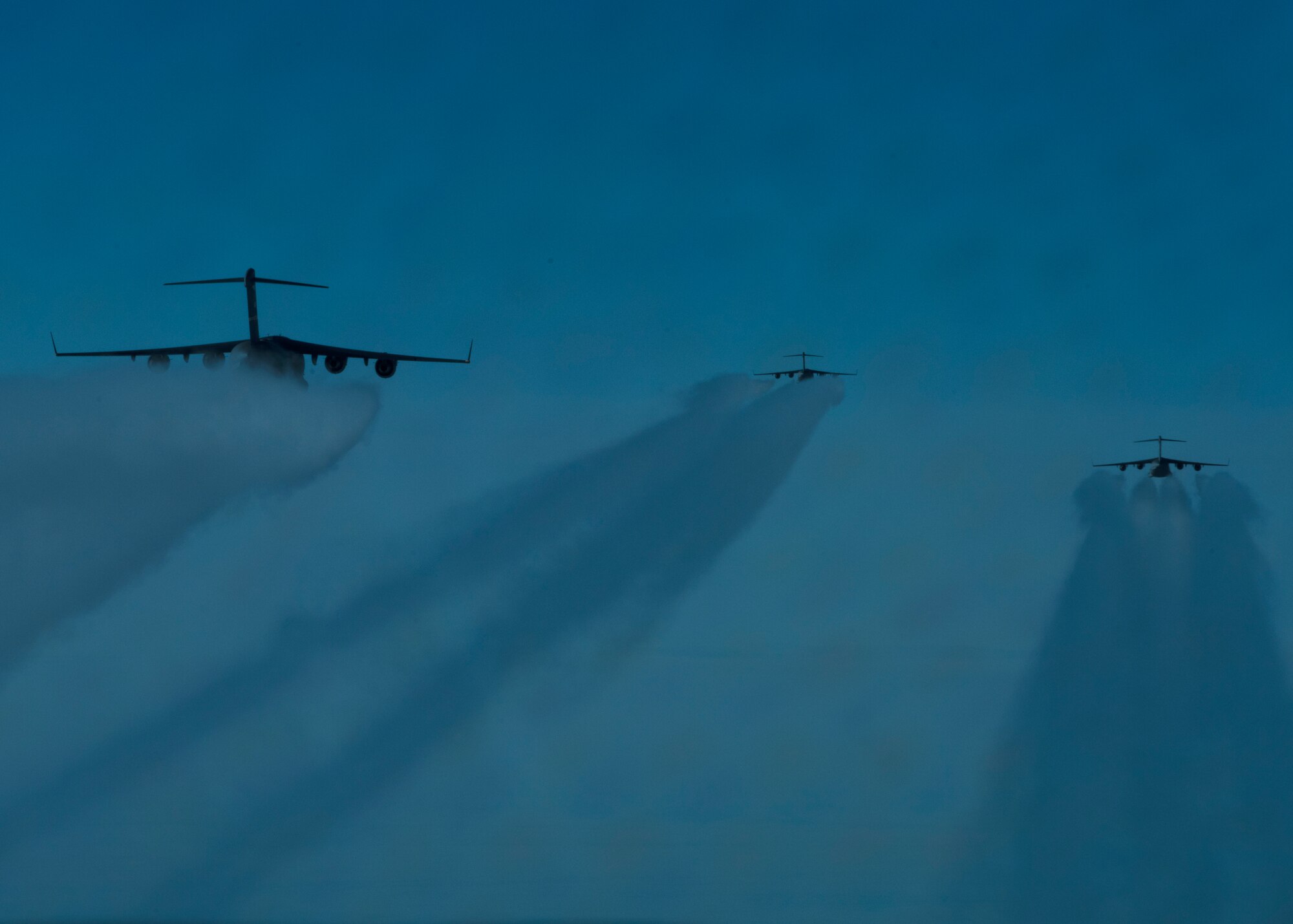 Three C-17 Globemaster III’s fly in formation over the Arctic Ocean during Exercise Swift Response May 9, 2022. Exercise Swift Response focuses on building airborne interoperability with Allies and partners, and the integration of joint service partners in a contested environment; testing the capability and operational reach to rapidly deploy and employ U.S. and Europe-based multi-national airborne forces with little to no warning from across the globe. (U.S. Air Force photo by Staff Sgt. Zoe Thacker)