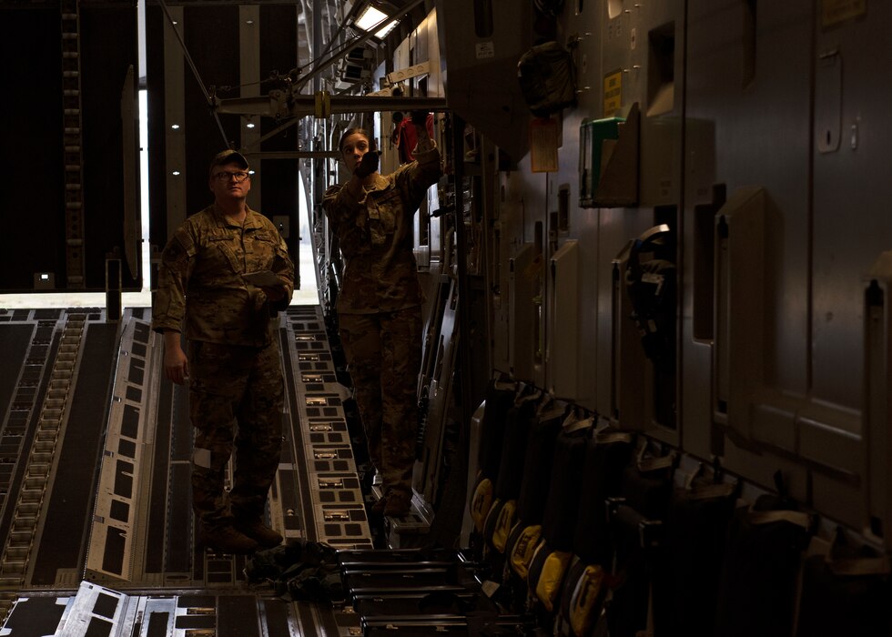 (From left) U.S. Air Force Staff Sgt. Brandon Hanson and U.S. Air Force Staff Sgt. Kate Cook, both 7th Airlift Squadron loadmasters, prepare a C-17 Globemaster III for an airdrop mission as part of Exercise Swift Response at Joint Base Elmendorf-Richardson, Alaska, May 9, 2022. Approximately 9,000 service members from 17 Allied and partner nations will participate in Swift Response, including approximately 2,700 U.S. Soldiers and Airmen. (U.S. Air Force photo by Staff Sgt. Zoe Thacker)