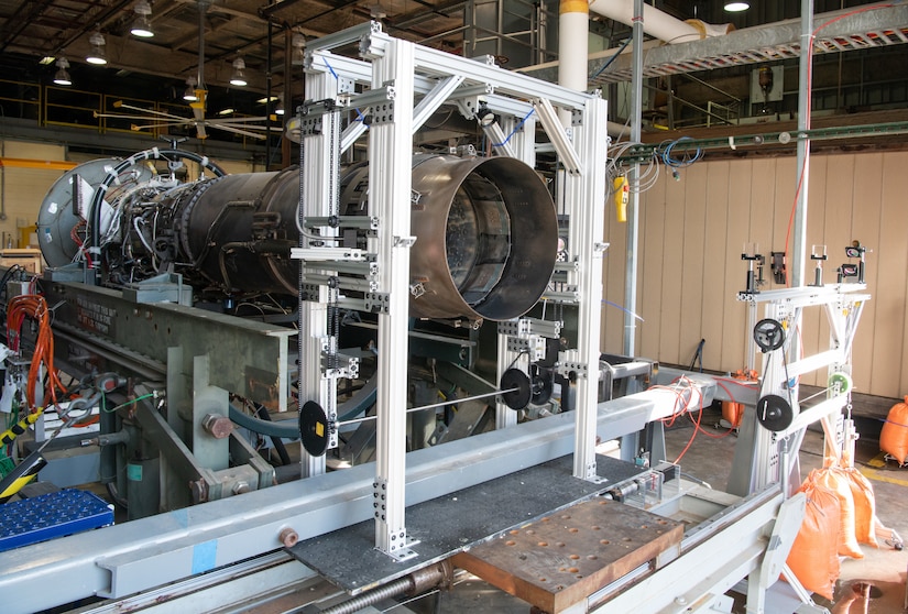 A jet engine is mounted indoors in a stand.