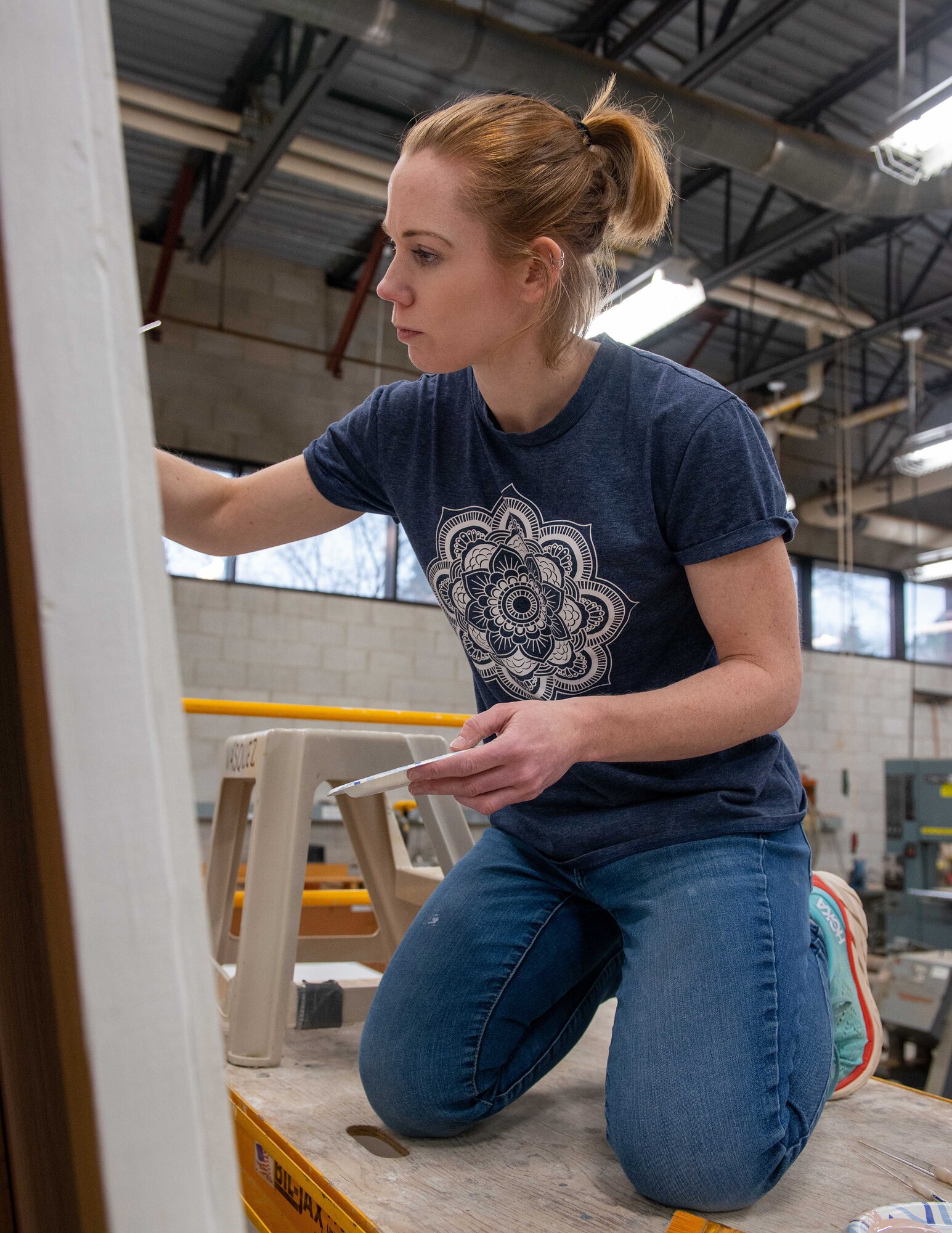Elizabeth Swanson, the 934th Airlift Wing Sexual Assault Response Coordinator, paints a mural at the Minneapolis-Saint Paul Air Reserve Station, March 24, 2022. Swanson has been working on the mural since January this year in preparation for Sexual Assault Awareness Month. (U.S. Air Force photo by Staff Sgt. Timothy Leddick, Jr.)