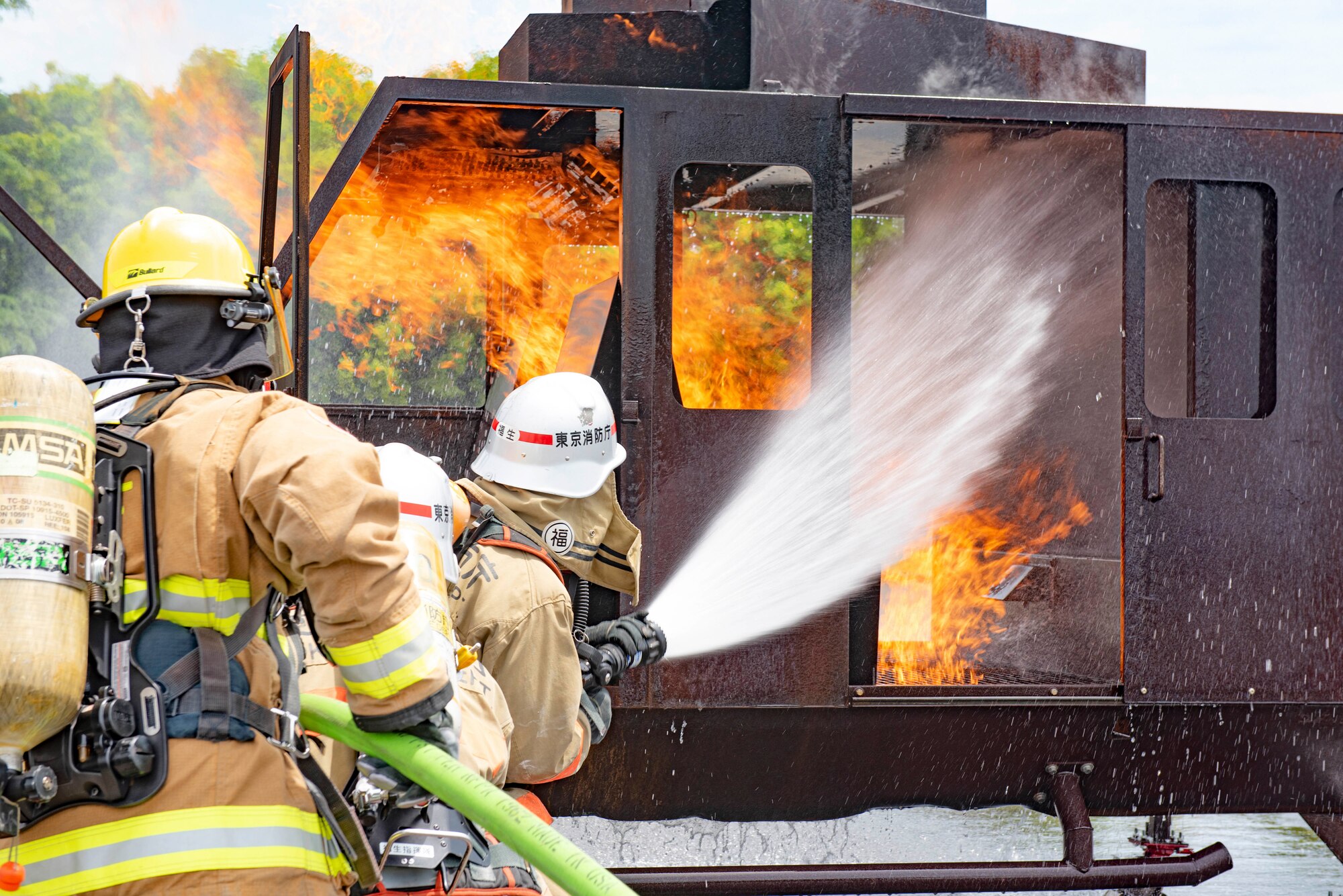 Firefighters with the 374th Civil Engineer Squadron Fire Department and Tokyo Fire Department, Fussa Fire Station, spray an aircraft fire trainer with water during a major accident response exercise at Yokota Air Base, Japan, May 11, 2022. The MARE tested the base’s response to a simulated F-16 Fighting Falcon crash and the ability to collaborate with mission partners. Due to the support of Naval Air Facility Atsugi, Commander Fleet Activities Yokosuka, Misawa Air Base and Tokyo Fire Department, Fussa Fire Station, this was the largest MARE in Yokota history. (U.S. Air Force photo by Machiko Arita)