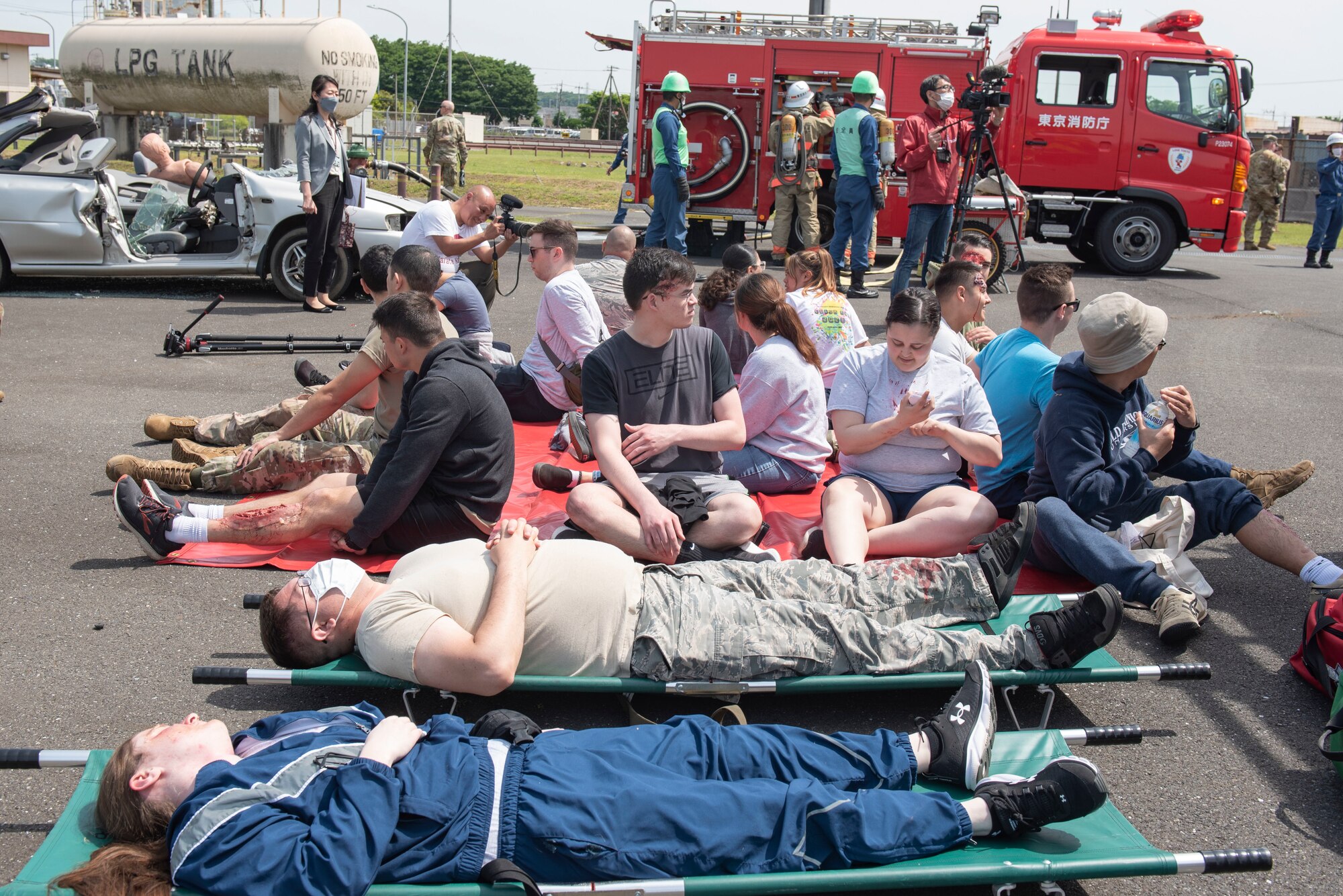Simulated injured people are triaged at a casualty collection point during a major accident response exercise at Yokota Air Base, Japan, May 11, 2022. The MARE tested the base’s response to a simulated F-16 Fighting Falcon crash and the ability to collaborate with mission partners. Due to the support of Naval Air Facility Atsugi, Commander Fleet Activities Yokosuka, Misawa Air Base and Tokyo Fire Department, Fussa Fire Station, this was the largest MARE in Yokota history. (U.S. Air Force photo by Machiko Arita)