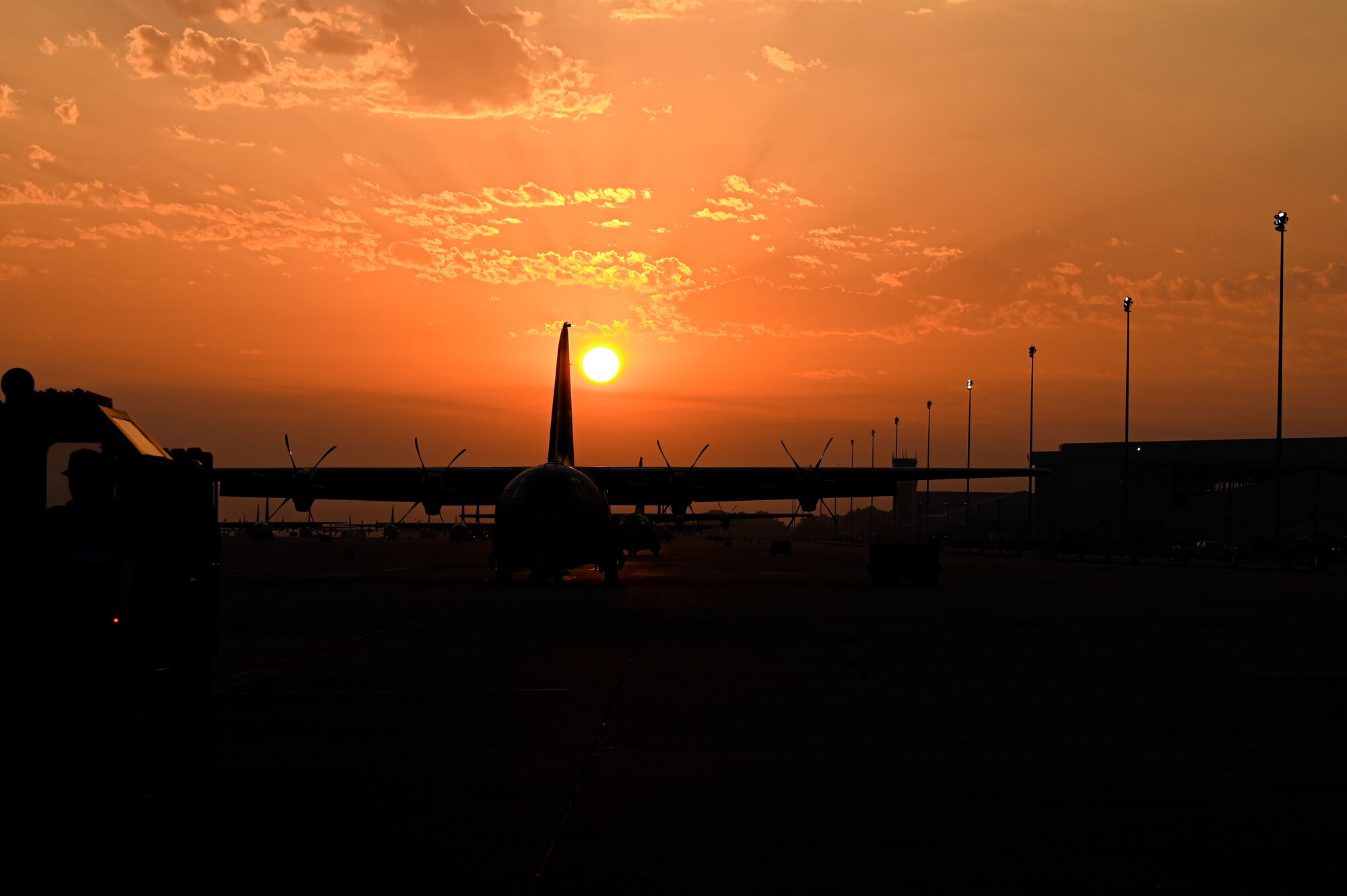 A C-130J Super Hercules is parked on the flightline as the sun rises above Little Rock Air Force Base