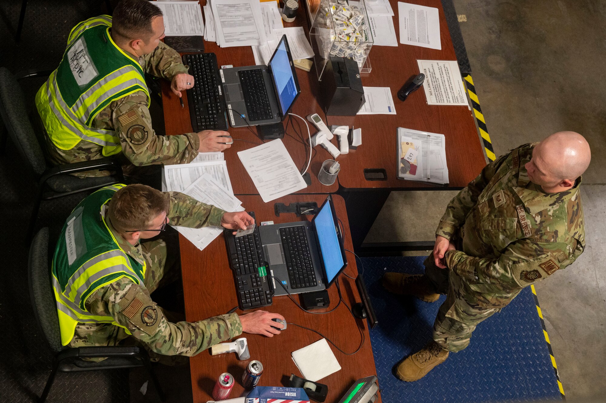 Tech. Sgt. Brandon Temple, 19th Maintenance Squadron munitions inspector, right, processes through the personnel deployment function line during Phase 1 of ROCKI 22-03