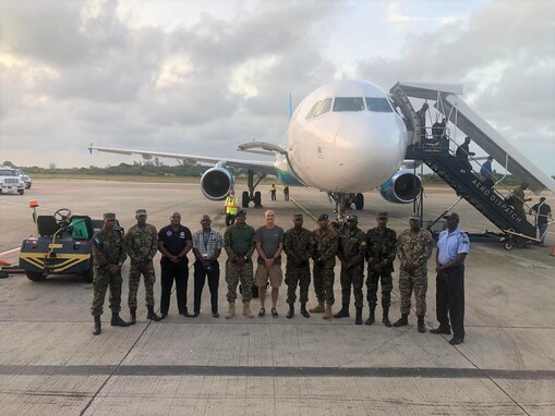 Members of the Regional Security System and the president of World Hope International (center) pose in front of the plane chartered to bring them and donated goods to the Tradewinds 22 exercise. Tradewinds is a Caribbean-focused exercise designed to expand the region’s capability to mitigate, plan for, and respond to crises; strengthen partnerships; increase regional training capacity and interoperability; develop new and refine existing Standard Operating Procedures (SOPs) during the SOP Development Conference; determine SOPs to be exercised; determine regional process for SOP validation; enhance ability to defend Exclusive Economic Zones; increase U.S./ally/partner readiness; promote human rights and adherence to shared international norms and values; fully integrate women into the force; and increase maritime domain awareness to deter IUU fishing activities. (Courtesy photo)