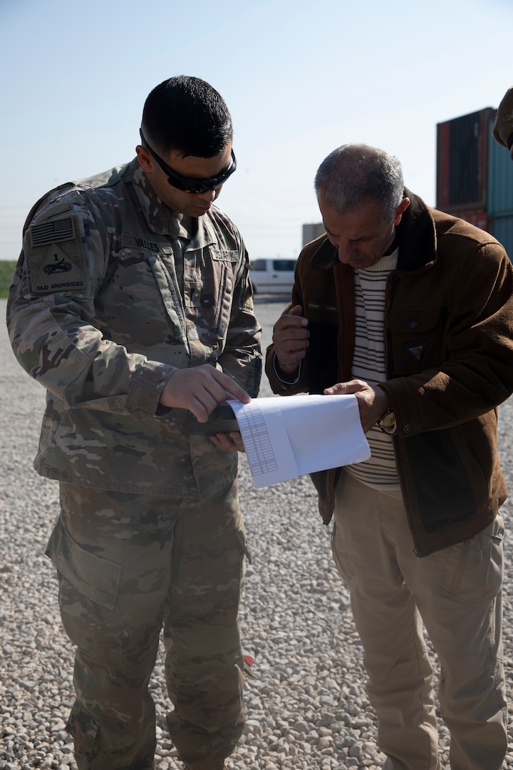 Brig. Gen. Shezard Nanaki, head of the Committee for the Delivery of New Aide from the International Coalition, and U.S. Army 1st Lt. Raphael Valles, reporting officer with the Counter-ISIS Train and Equip Fund (CTEF) program, reviews forms at Erbil Air Base, Iraq, March 8, 2022. The Combined Joint Task Force - Operation Inherent Resolve’s CTEF program has divested more than $500 million of equipment, vehicles, weapons and ammunition in an effort to advise, assist, and enable partner forces in the enduring defeat of Daesh. (U.S. Army photo by Cpl. Tommy L. Spitzer)