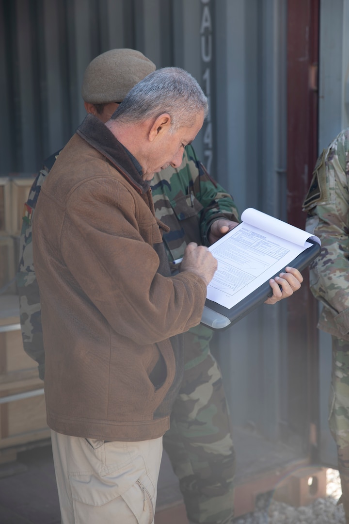 Brig. Gen. Shezard Nanaki, head of the Committee for the Delivery of New Aide from the International Coalition, signs forms verifying the amount of ammunition being divested at Erbil Air Base, Iraq, March 8, 2022. The Combined Joint Task Force - Operation Inherent Resolve’s CTEF program has divested more than $500 million of equipment, vehicles, weapons and ammunition in an effort to advise, assist, and enable partner forces in the enduring defeat of Daesh. (U.S. Army photo by Cpl. Tommy L. Spitzer)