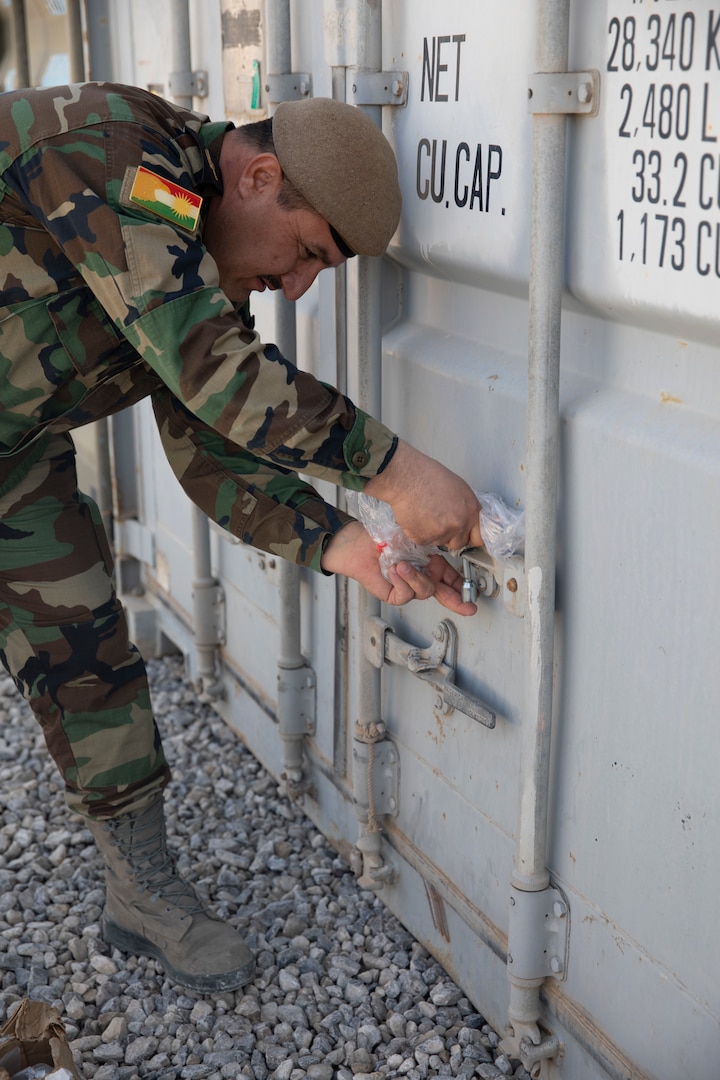 Maj. Arkan Awla Perot, M4 warehouse liaison, secures containers of ammunition being divested at Erbil Air Base, Iraq, March 8, 2022. The Combined Joint Task Force - Operation Inherent Resolve’s CTEF program has divested more than $500 million of equipment, vehicles, weapons and ammunition in an effort to advise, assist, and enable partner forces in the enduring defeat of Daesh. (U.S. Army photo by Cpl. Tommy L. Spitzer)