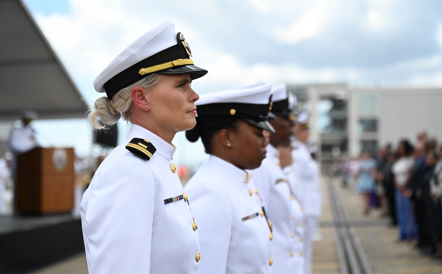 Sailors stand at attention in front of the crowd during the commissioning of the Navy’s newest Arleigh Burke-class guided-missile destroyer USS Frank E. Petersen Jr. (DDG 121) in Charleston, S.C., May 14, 2022.