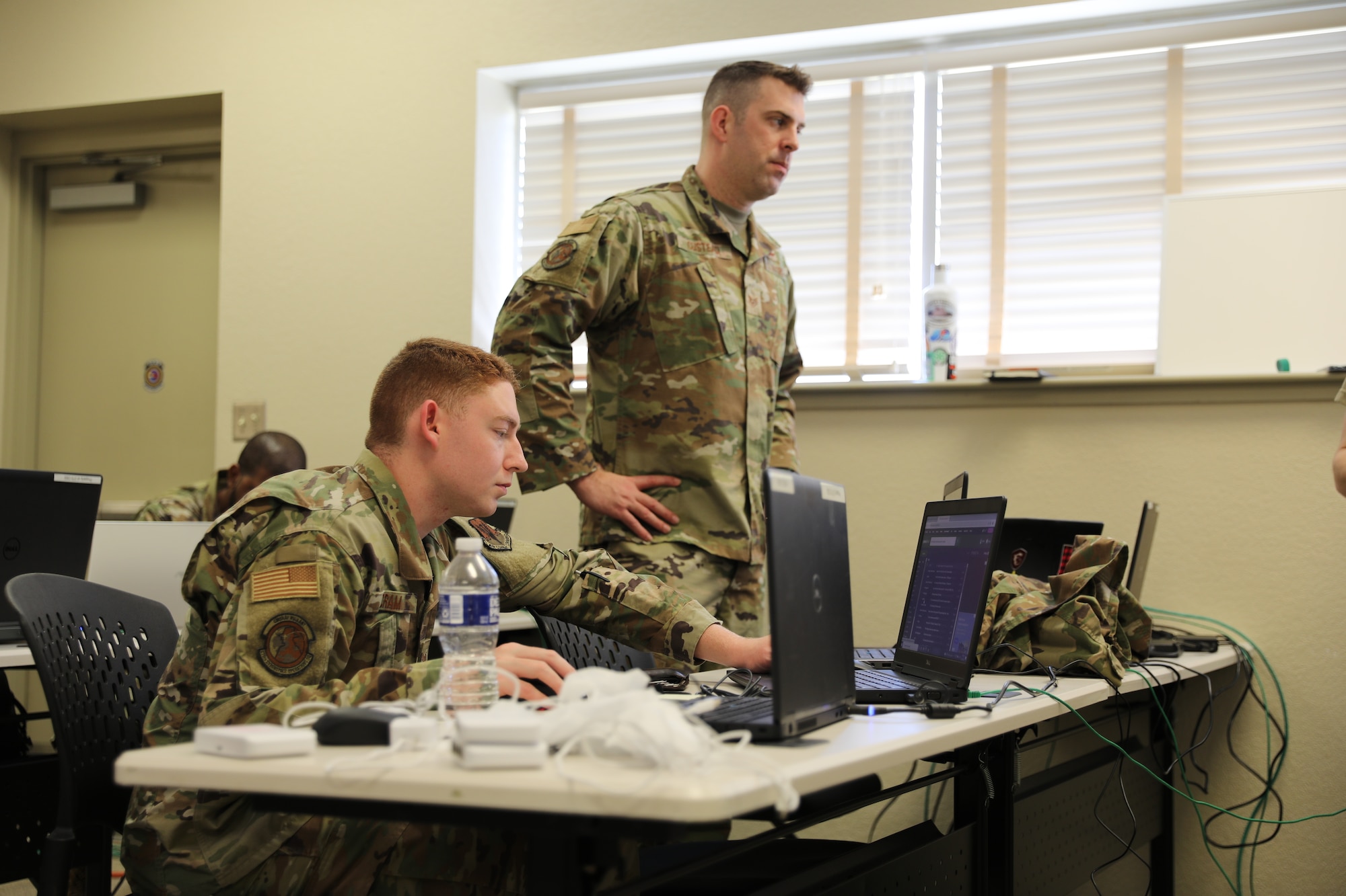 U.S. Air Force Staff Sgt. Austin Cram and Staff Sgt. Nicholas Custead with 175th Cyberspace Operations Squadron, 175th Wing, Maryland Air National Guard, based in Middle River, Maryland, prepare their work stations at Southern Strike 2022 at the Gulfport Combat Readiness Training Center Gulfport, Mississippi, April 27, 2022. Southern Strike 2022 is an excellent test of joint teams' ability to conduct major campaign, crisis response and security cooperation operations. (U.S. Army National Guard photo by Spc. Benjamin Tomlinson)