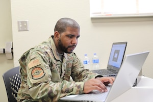U.S. Air Force Staff Sgt. Demetrius Deck with 175th Cyberspace Operations Squadron, 175th Wing, Maryland Air National Guard, based in Middle River, Maryland, prepares his work station during Southern Strike 2022 at the Gulfport Combat Readiness Training Center Gulfport, Mississippi, April 27, 2022. Southern Strike 2022 is an excellent test of joint teams' ability to conduct major campaign, crisis response and security cooperation operations. (U.S. Army National Guard photo by Spc. Benjamin Tomlinson)
