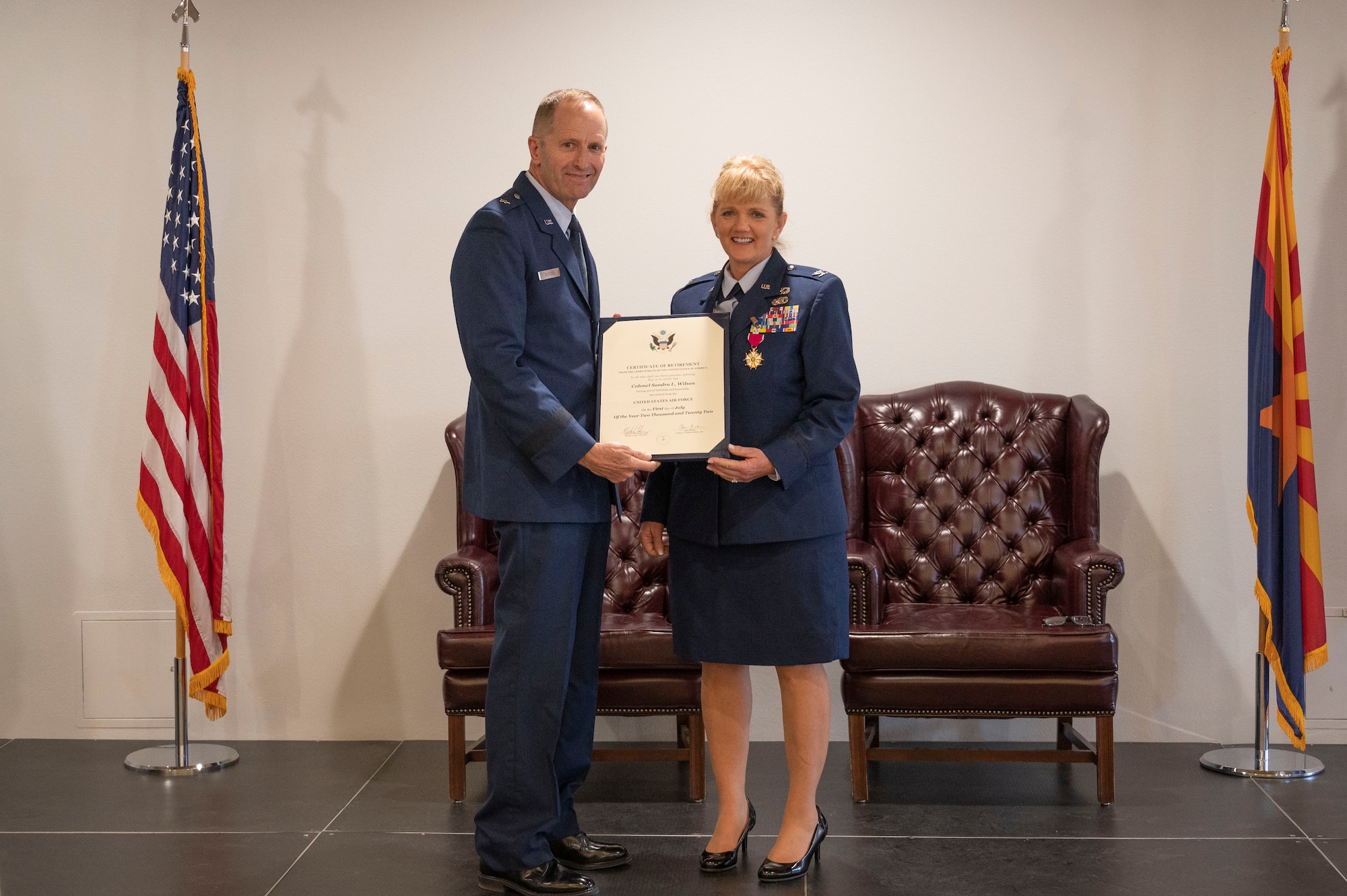 U.S. Air Force Brig. Gen. Jeffrey Butler, left, 162nd Wing Commander, presents Col. Sandra L. Wilson with a  certificate of retirement at Morris Air National Guard Base, May 14, 2022. (Air National Guard photo by Senior Master Sgt. Charles Givens)