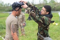 A New York National Guard Soldier with the 222nd Chemical Company, 104th Military Police Battalion performs a decontamination exercise at Fort Indiantown Gap on May 14. Another solider carefully removes the gas mask for gear decontaminating.