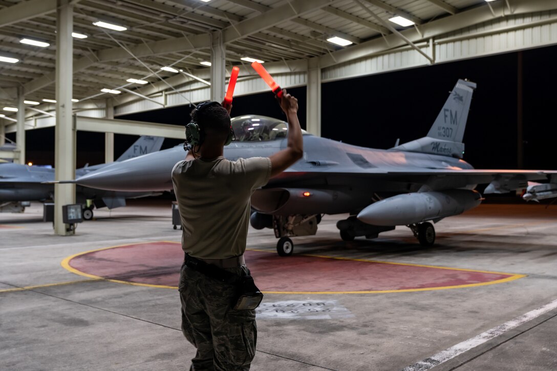 A crew chief assigned to the 482nd Aircraft Maintenance Squadron marshals out an F-16 Fighting Falcon for a night time training mission at Homestead Air Reserve Base, Fla., March 24, 2020.