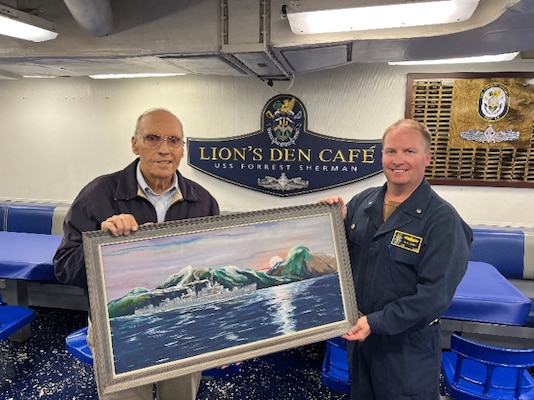 Retired Cmdr. George Keller presents a painting of USS Forrest Sherman (DD-931) to Cmdr. Greg Page, commanding officer of the Arleigh Burke-class guided missile destroyer USS Forrest Sherman (DDG 98). USS Forrest Sherman is in port for a scheduled
maintenance period. (U.S. Navy Photo by Lt. j.g. Kathleen Barrios)