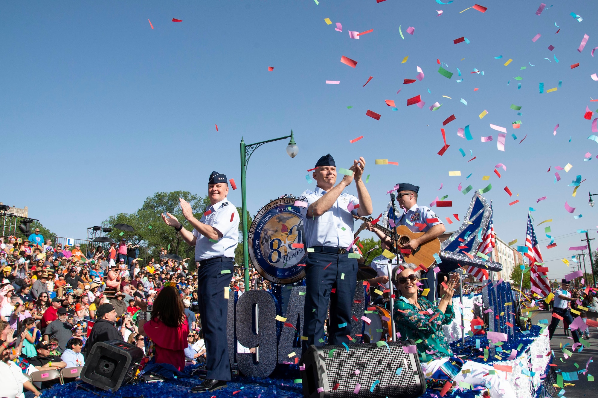 Lt. Gen. Brad Webb, commander of Air Education and Training Command, and Chief Master Sgt. Erik Thompson, AETC command chief, wave and cheer to the crowd during the Texas Cavaliers Fiesta River Parade in San Antonio, Texas