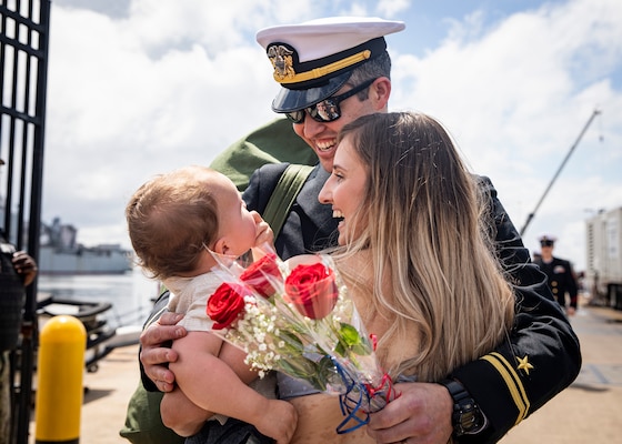 Lt. j.g. Mark Driver, assigned to the Los Angeles-class fast-attack submarine USS Albany (SSN 753), embraces his wife, Maya, and son, Kellen, during the boat’s homecoming to Naval Station Norfolk, May 14, 2022.