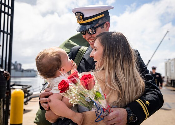 Lt. j.g. Mark Driver, assigned to the Los Angeles-class fast-attack submarine USS Albany (SSN 753), embraces his wife, Maya, and son, Kellen, during the boat’s homecoming to Naval Station Norfolk, May 14, 2022.