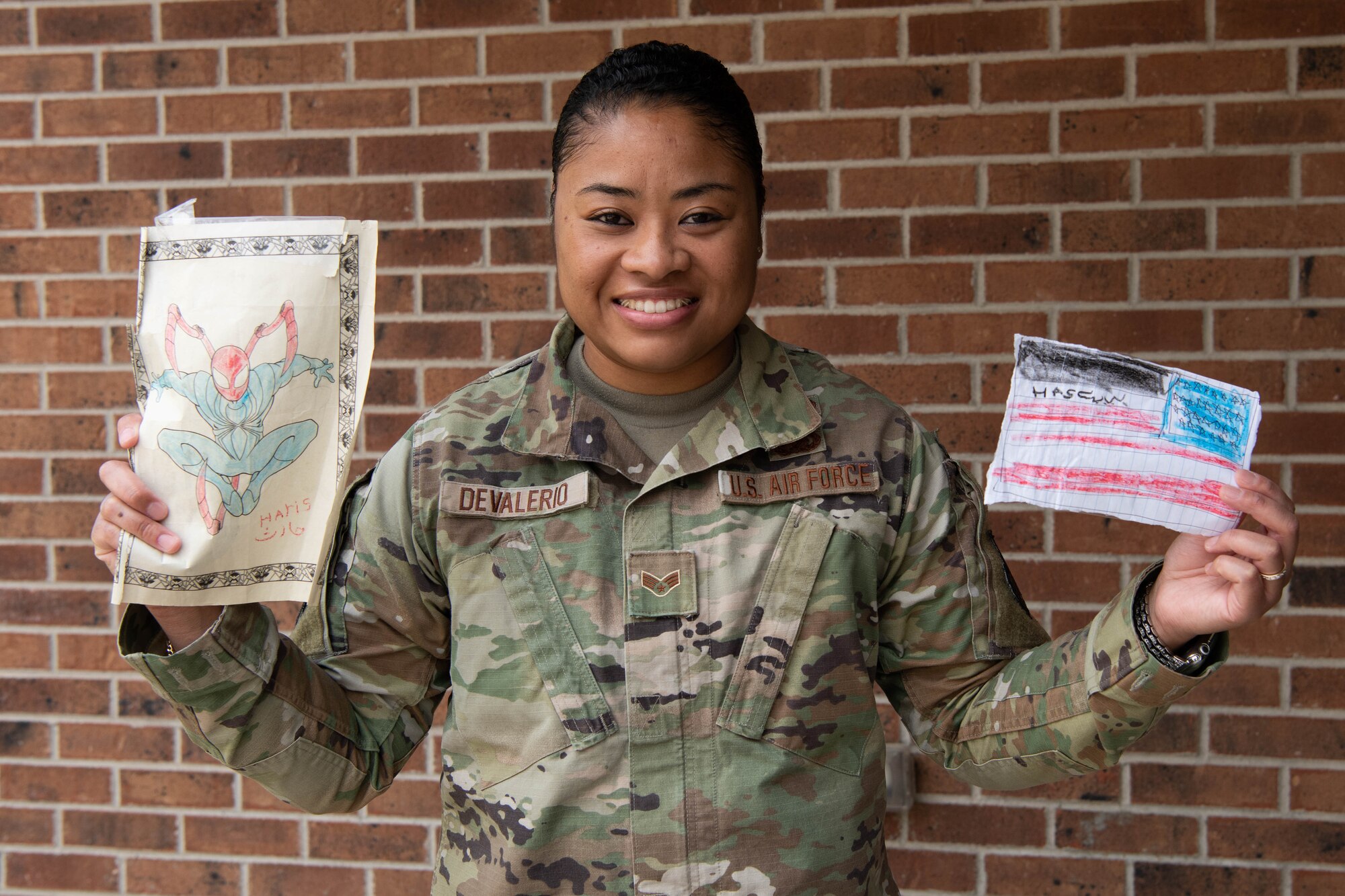Senior Airman Shawnte DeValerio, 302nd Airlift Wing Judge Advocate office, poses with artwork she got during her deployment supporting Operation Allies Welcome