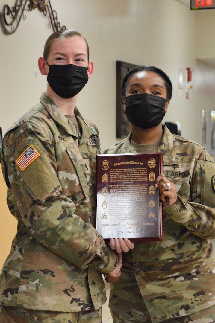 Command Sgt. Maj. Shavonda Devereaux, senior enlisted advisor for Bayne-Jones Army Community Hospital presents Staff Sgt. Tabitha Moore with a plaque for winning the BJACH NCO of the Year Competition