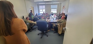 Photo of USAF Airmen participating in a table-top exercise sitting around a table