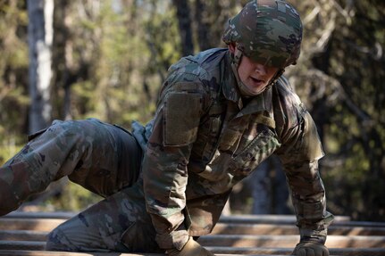 A soldier completes the High-Step-Over obstacle during the Best Warrior Competition on Joint Base Elmendorf-Richardson, May 11, 2022. The six-day competition tests Soldiers’ mental and physical agility and toughness through a series of battle-focused events that measure technical and tactical proficiency. (U.S. Army National Guard photo by Victoria Granado)