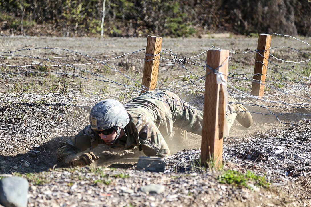 Sgt. Ricardo Morales, a military police Soldier assigned to Company A, 49th Missile Defense Battalion finishes the obstacle course with a low crawl under barbed wire during the Best Warrior Competition held at Joint Base Elmendorf-Richardson, Alaska May 11. Competitors are evaluated on their individual abilities to adapt to and overcome challenging scenarios and battle-focused events, which test their technical and tactical abilities under stress and heavy fatigue. (Alaska National Guard Photo by Staff Sgt. Katie Mazos-Vega)