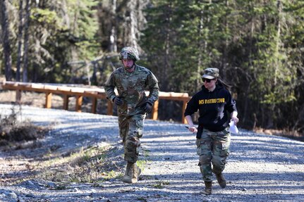 Spc. Austin Morton, assigned to Company A, 49th Missile Defense Battalion, runs with Sgt. 1st Class Melissa Ferguson, an instructor for the Best Warrior Competition, during the obstacle course event at Joint Base Elmendorf-Richardson, Alaska, May 11. The six-day competition tests Soldiers’ mental and physical agility and toughness through a series of events that measure technical and tactical proficiency. (Alaska National Guard Photo by Staff Sgt. Katie Mazos-Vega)