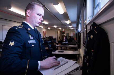 Spc. Austin Morton, a military police Soldier assigned to Company A, 49th Missile Defense Battalion, inspects an army service uniform as part of a test for the Best Warrior Competition held at Joint Base Elmendorf Richardson, Alaska, May 13, 2022. The six-day competition tests Soldiers’ mental and physical agility and toughness through a series of events that measure technical and tactical proficiency. (U.S. Army National Guard photo by Victoria Granado)