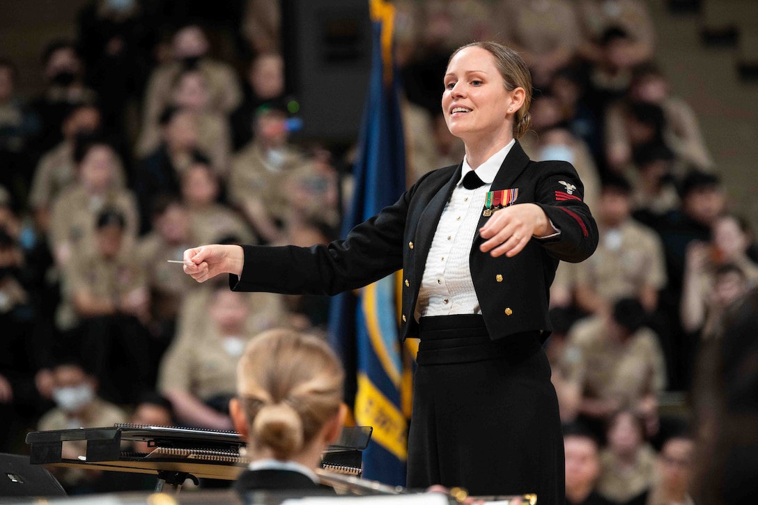 A sailor conducts a band.