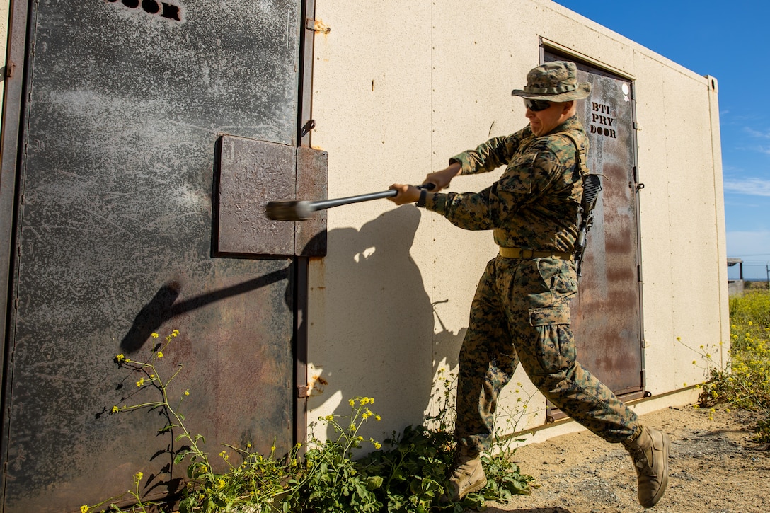 U.S. Marine Corps Pfc. Darren Espil, a rifleman, with Golf Company, Battalion Landing Team 2/4, 13th Marine Expeditionary Unit, swings a sledgehammer as a method to breach as part of a Mechanized Raid course at Marine Corps Base Camp Pendleton, Calif., May 10, 2022. The raid course was a one week program designed to improve the Marines’ ability to plan and conduct limited scale raids utilizing ground movement while forward deployed in the Indo-Pacific region.