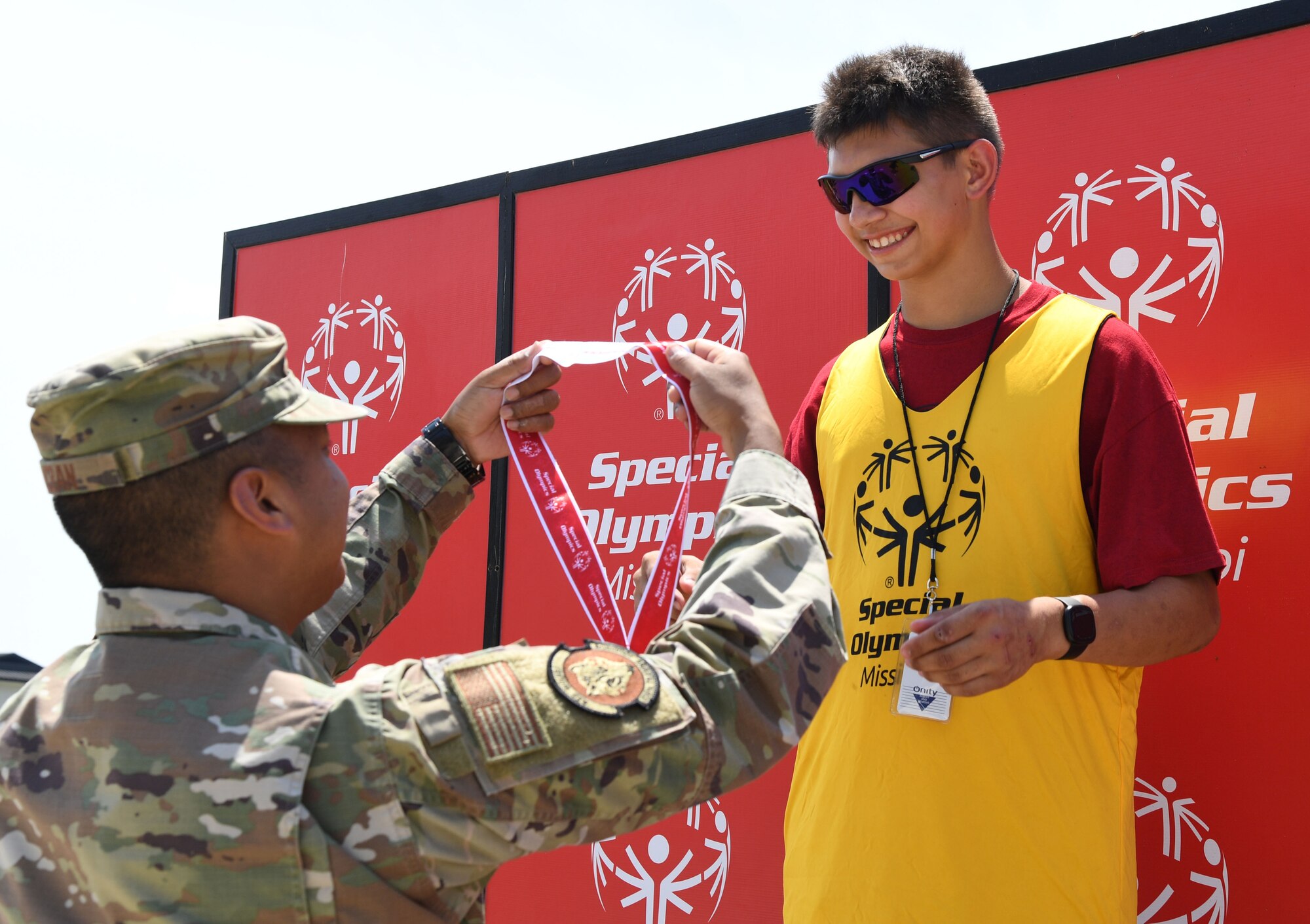 U.S. Air Force Maj. Marc Icban, 336th Training Squadron deputy commander, presents a medal to Ryan Damico, Area 16 athlete, during the Special Olympics Mississippi Summer Games at Keesler Air Force Base, Miss., May 14, 2022. Over 600 athletes participated in the Summer Games. (U.S. Air Force photo by Kemberly Groue)