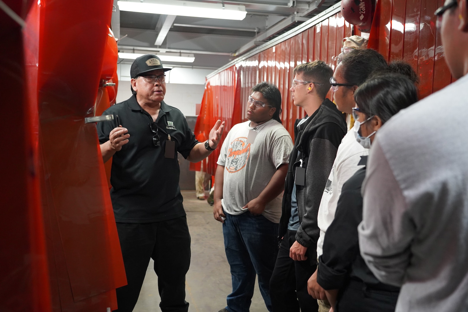 Randal Amoncio (left), an apprentice instructor for Pearl Harbor Naval Shipyard and Intermediate Maintenance Facility (PHNSY & IMF) describes the various welding skills taught in the shipyard’s apprentice program to James Campbell High School students during a career-oriented field trip held in mid-April. This event is one of several PHNSY & IMF community outreach programs conducted with local schools. The visit gathered 26 students and three teachers from the school’s Science, Technology, Engineering, Arts, and Mathematics (STEAM) program that offers students insight in trade industry occupations. During the field trip, representatives from the shipyard’s Production Resource Training Department facilitated the students’ experience with a tour of its welding school including welding demonstrations and an overview of equipment and training facilities used in honing welding trade skills. (Official U.S. Navy photo by Justice M. Vannatta)