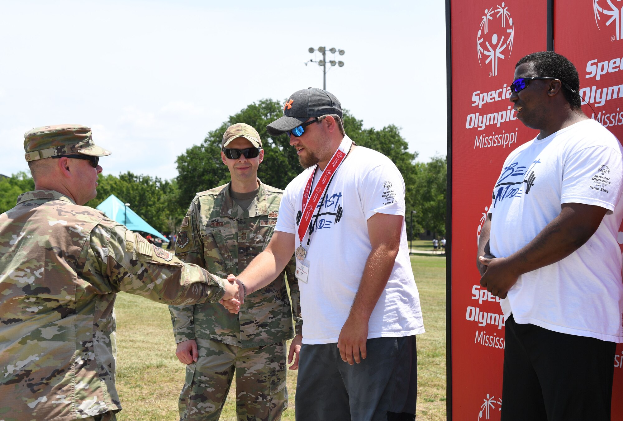 Keesler leadership presents medals to athletes during the Special Olympics Mississippi Summer Games at Keesler Air Force Base, Miss., May 14, 2022. Over 600 athletes participated in the Summer Games. (U.S. Air Force photo by Kemberly Groue)