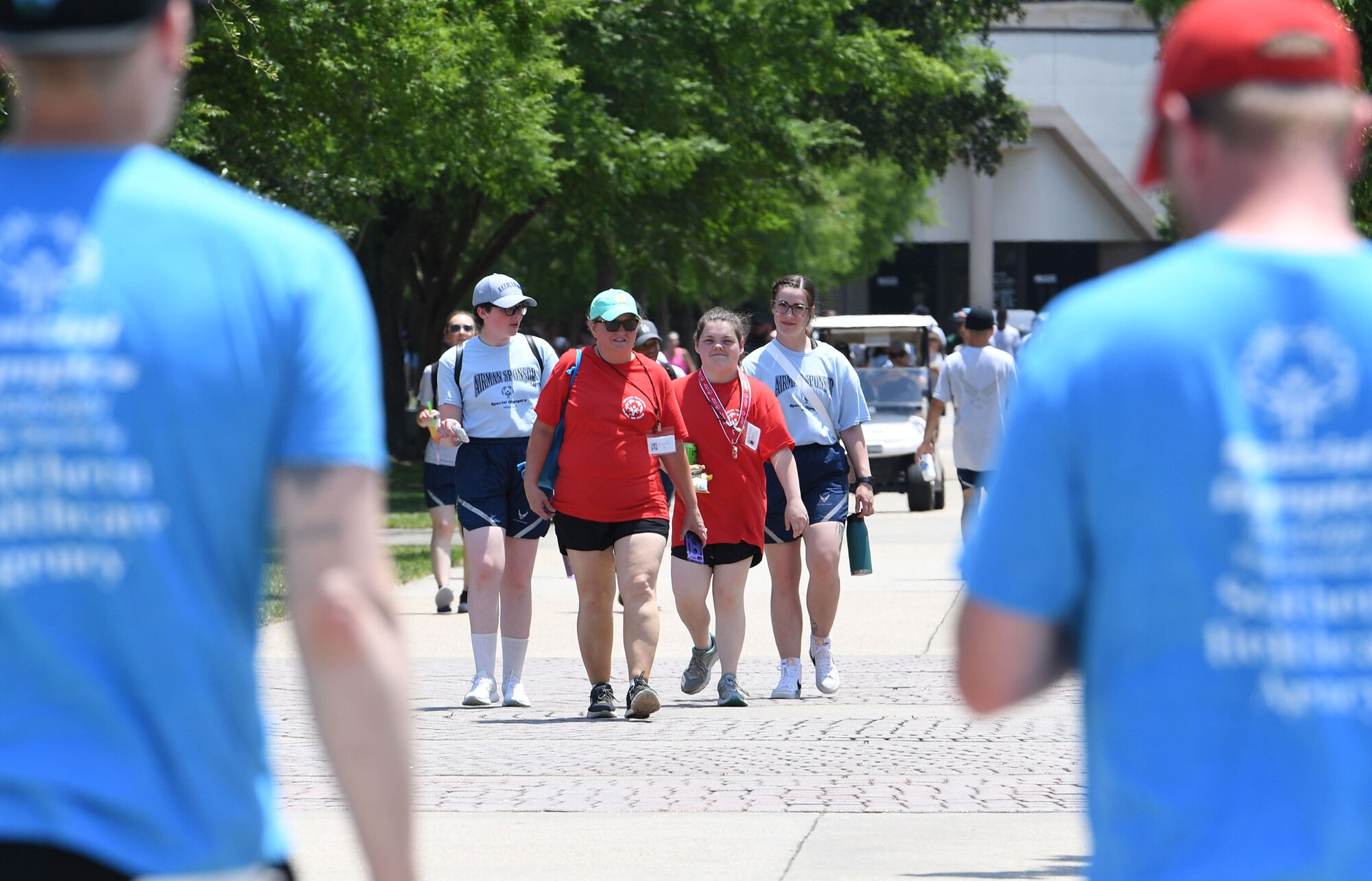 Airman sponsors and athletes walk to the events area during the Special Olympics Mississippi Summer Games at Keesler Air Force Base, Miss., May 14, 2022. Over 600 athletes participated in the Summer Games. (U.S. Air Force photo by Kemberly Groue)