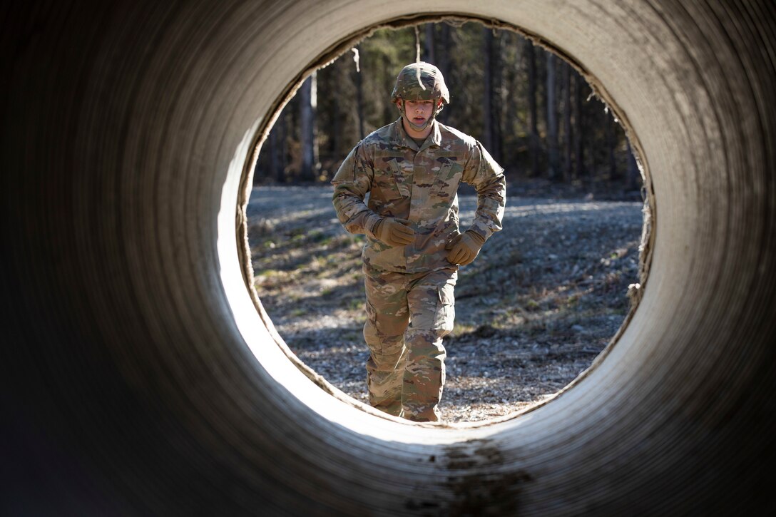 Spc. Shane Sims, assigned to 207th Engineer Utilities Detachment, approaches a tunnel in an obstacle course during the Best Warrior Competition on Joint Base Elmendorf-Richardson, May 11, 2022. The six-day competition tests Soldiers’ mental and physical agility and toughness through a series of battle-focused events that measure technical and tactical proficiency. (Alaska National Guard photo by Victoria Granado)