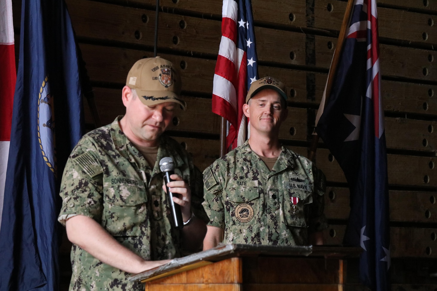 DARWIN, Australia (May 11, 2022) Cmdr. Dirk Sonnenberg, left, 22nd commanding officer of the forward-deployed amphibious dock landing ship USS Ashland (LSD 48), reads his orders during Ashland’s change-of-command ceremony, May 11 in Australia. Ashland, part of Amphibious Squadron 11, is operating in the U.S. 7th Fleet area of responsibility to enhance interoperability with allies and partners, and serve as a ready response force to defend peace and stability in the Indo-Pacific region. (U.S. Navy photo by Lt. j.g. John Malik)