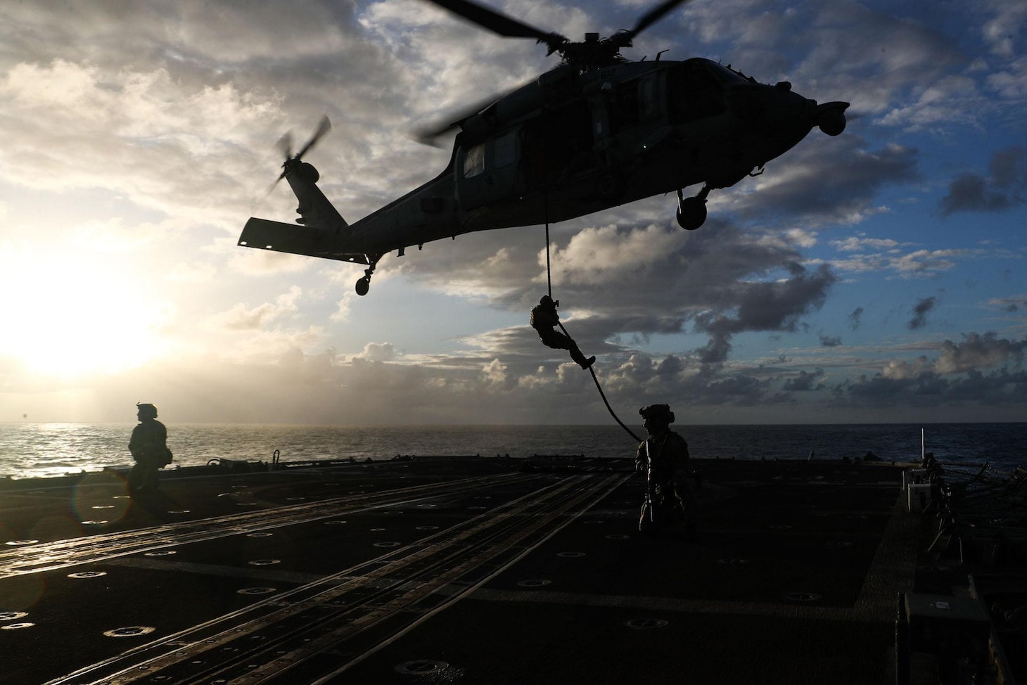 PHILIPPINE SEA (May 11, 2022) Sailors, assigned to Explosive Ordnance Disposal Mobile Unit (EODMU) 3, rope down from an MH-60S Sea Hawk helicopter, assigned to the “Chargers” of Helicopter Sea Combat Squadron (HSC) 14, onto the Ticonderoga-class guided-missile cruiser USS Mobile Bay (CG 53) during a helicopter visit, board, search and seizure (HVBSS) training. Abraham Lincoln Strike Group is on a scheduled deployment in the U.S. 7th Fleet area of operations to enhance interoperability through alliances and partnerships while serving as a ready-response force in support of a free and open Indo-Pacific region. (U.S. Navy photo by Mass Communication Specialist 3rd Class Alonzo Martin-Frazier)
