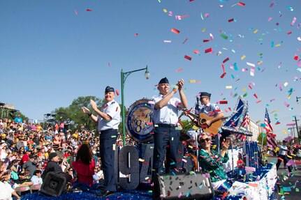 Lt. Gen. Brad Webb, commander of Air Education and Training Command, and Chief Master Sgt. Erik Thompson, AETC command chief, wave and cheer to the crowd during the Texas Cavaliers Fiesta River Parade in San Antonio, Texas