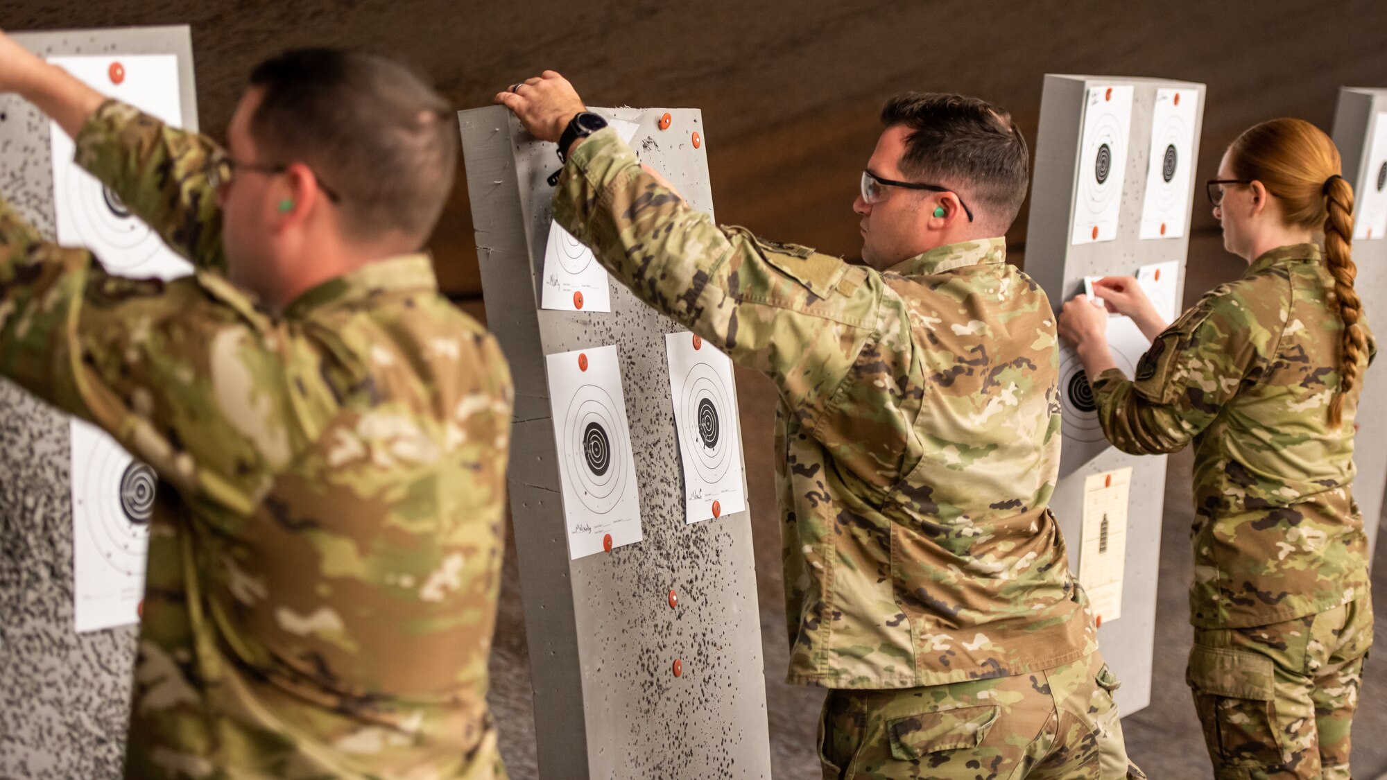 Members of Team Osan pull down their targets for scoring after the M4 portion of the excellence in competition event