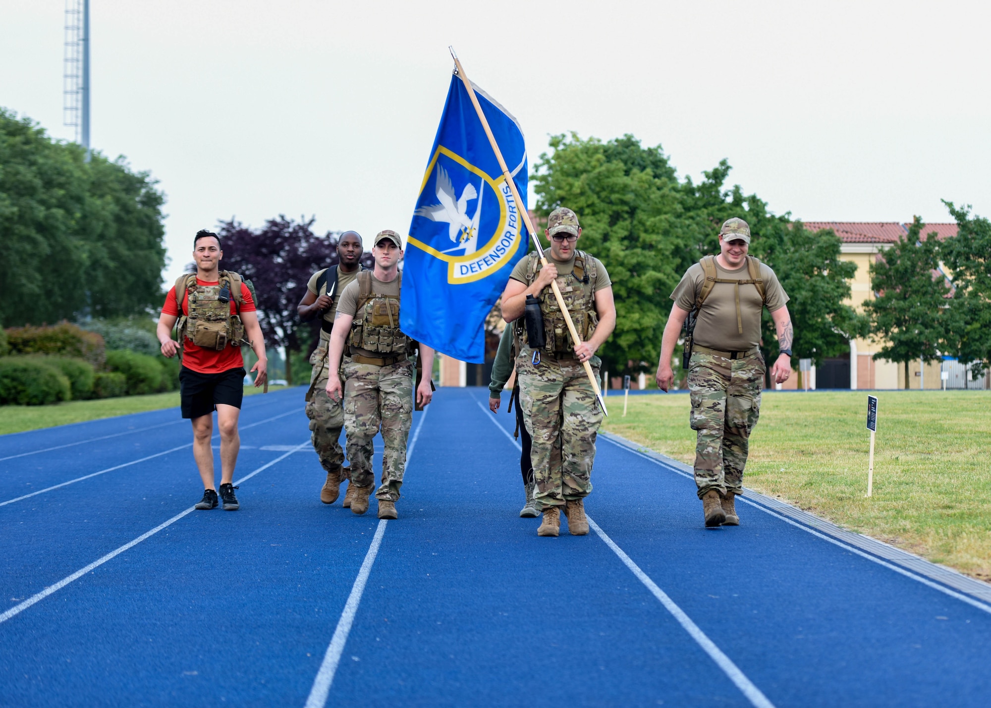 U.S. Air Force Airmen assigned to the 31st Fighter Wing participate in a Police Week 15-hour memorial ruck march on the track at Aviano Air Base, Italy, May 16, 2022. The participants carried the Defensor Fortis flag during the ruck to honor 15 fallen U.S. Air Force Security Forces members.  The participants walked, ran, or rucked in remembrance of the fallen. Police Week pays tribute to the local, state, and federal police officers who have died or have been disabled in the line of duty.  (U.S. Air Force photo by Senior Airman Brooke Moeder)