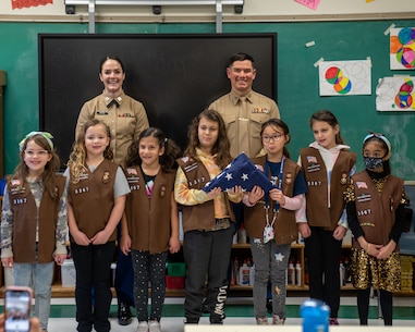 U.S. Marine Corps Capt. Maria Arnone, marketing and communication officer for 1st Marine Corps District, and Capt. Frank Cinturati, special projects officer for 1MCD, worked alongside Girl Scouts with Brownie Troop 3367 as they trained on flag folding protocols at Woodland Elementary School in Hicksville, New York, Feb. 4, 2022. (U.S. Marine Corps photo by 1stLt. Derek VanWyck)