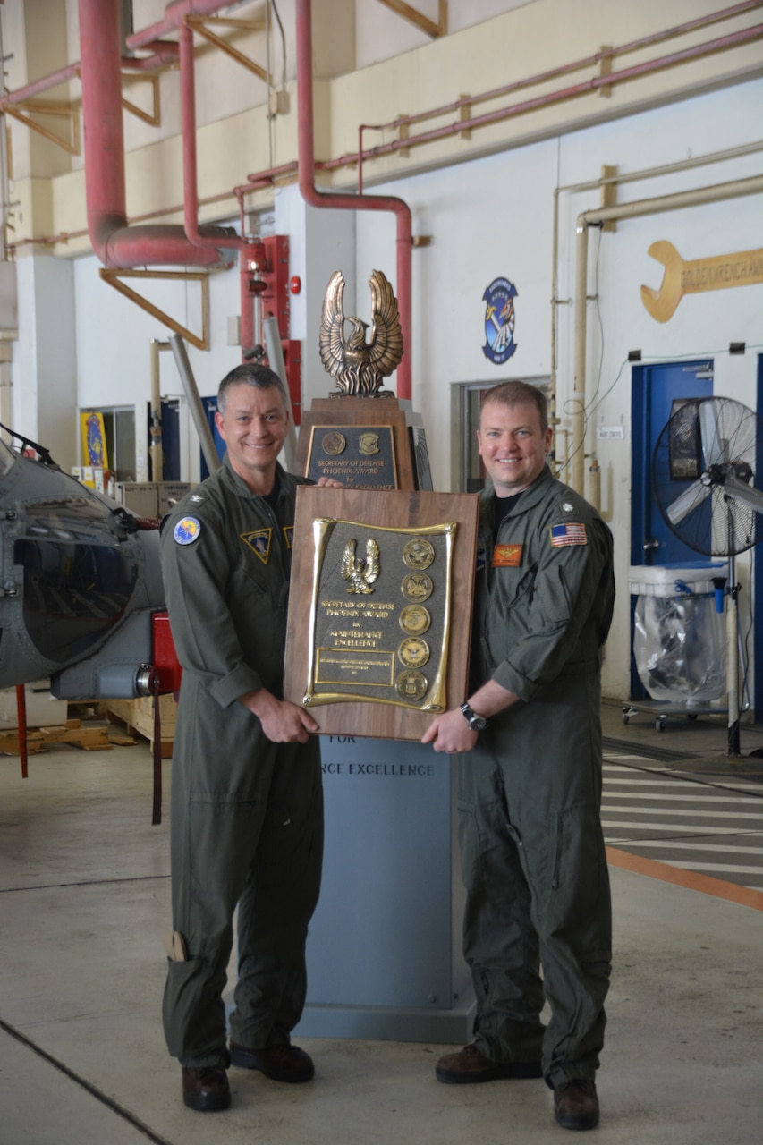 Capt. Michael Sweeney, commanding officer of Carrier Air Wing (CVW) 5 presents the Phoenix Award to Cmdr. Nicholas Cunningham, commanding officer of the "Saberhawks" of Helicopter Maritime Strike Squadron (HSM) 77 during a ceremony at the squadron's hangar at Naval Air Facility Atsugi, Japan. HSM 77 and CVW 5 are attached to Commander, Task Force (CTF) 70 and is forward-deployed to the 7th Area of Operation in support of a free and open Indo-Pacific.