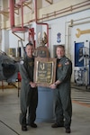 Capt. Michael Sweeney, commanding officer of Carrier Air Wing (CVW) 5 presents the Phoenix Award to Cmdr. Nicholas Cunningham, commanding officer of the "Saberhawks" of Helicopter Maritime Strike Squadron (HSM) 77 during a ceremony at the squadron's hangar at Naval Air Facility Atsugi, Japan. HSM 77 and CVW 5 are attached to Commander, Task Force (CTF) 70 and is forward-deployed to the 7th Area of Operation in support of a free and open Indo-Pacific.