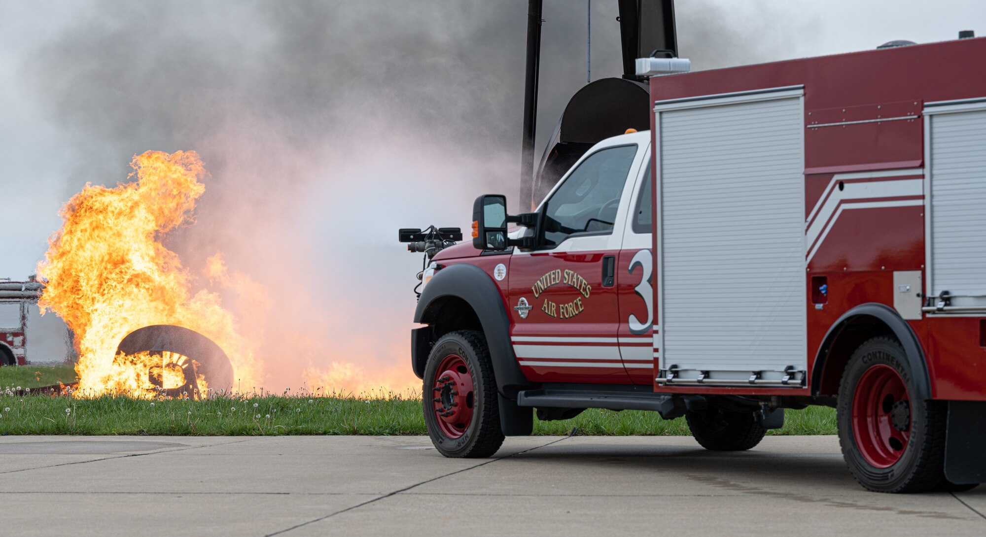 Fire protection specialists assigned to the 509th Civil Engineering Squadron conduct a training demonstration for a group of kindergarteners from Whiteman Elementary School during a base field trip on Whiteman Air Force Base, Missouri, May 4, 2022. The students toured various facilities on base receiving demonstrations from security forces and the fire department. (U.S. Air Force photo by Airman 1st Class Bryson Britt)