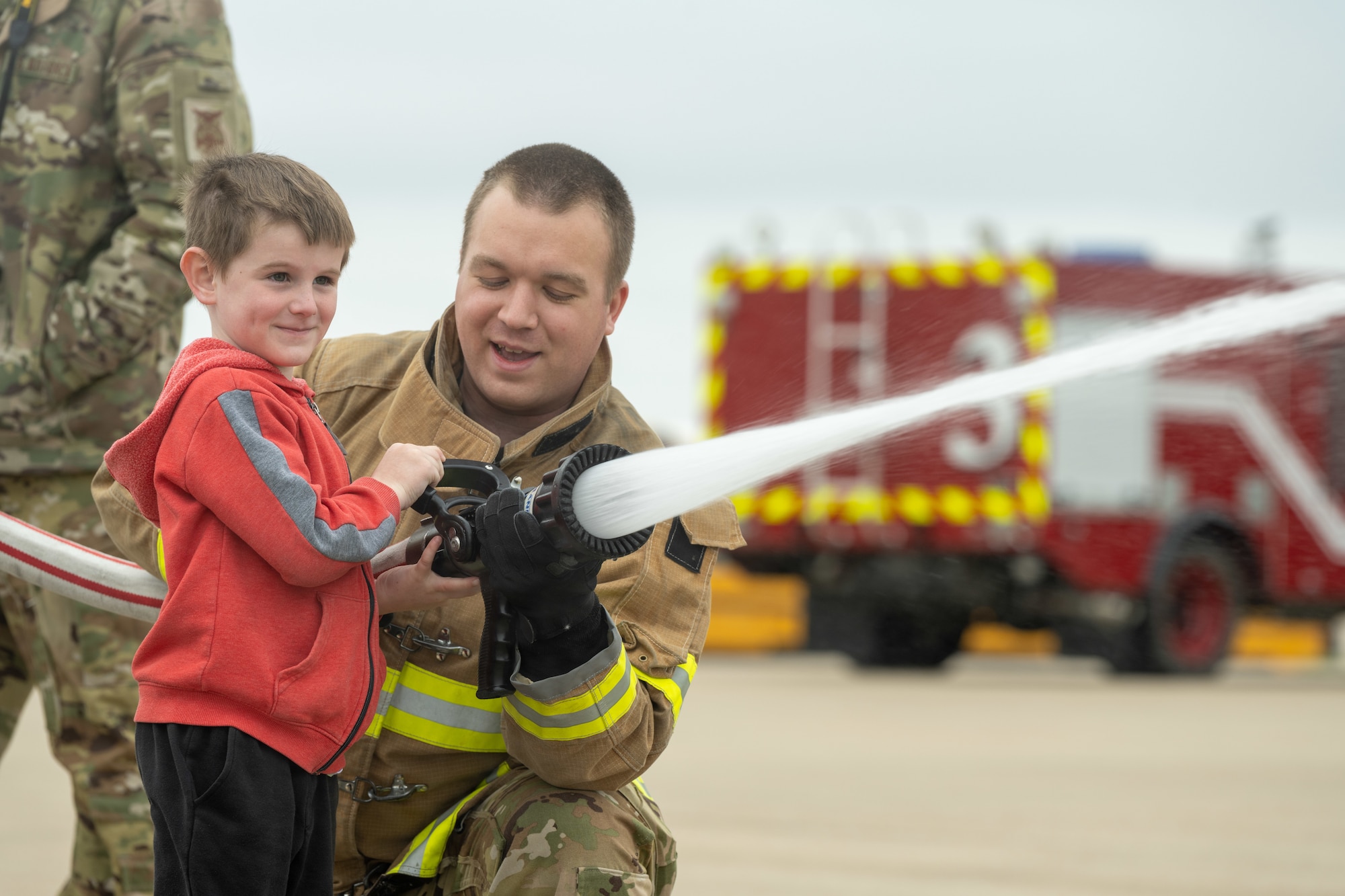 Fire protection specialists assigned to the 509th Civil Engineering Squadron conduct a training demonstration for a group of kindergarteners from Whiteman Elementary School during a base field trip on Whiteman Air Force Base, Missouri, May 4, 2022. The students toured various facilities on base receiving demonstrations from security forces and the fire department. (U.S. Air Force photo by Airman 1st Class Bryson Britt)