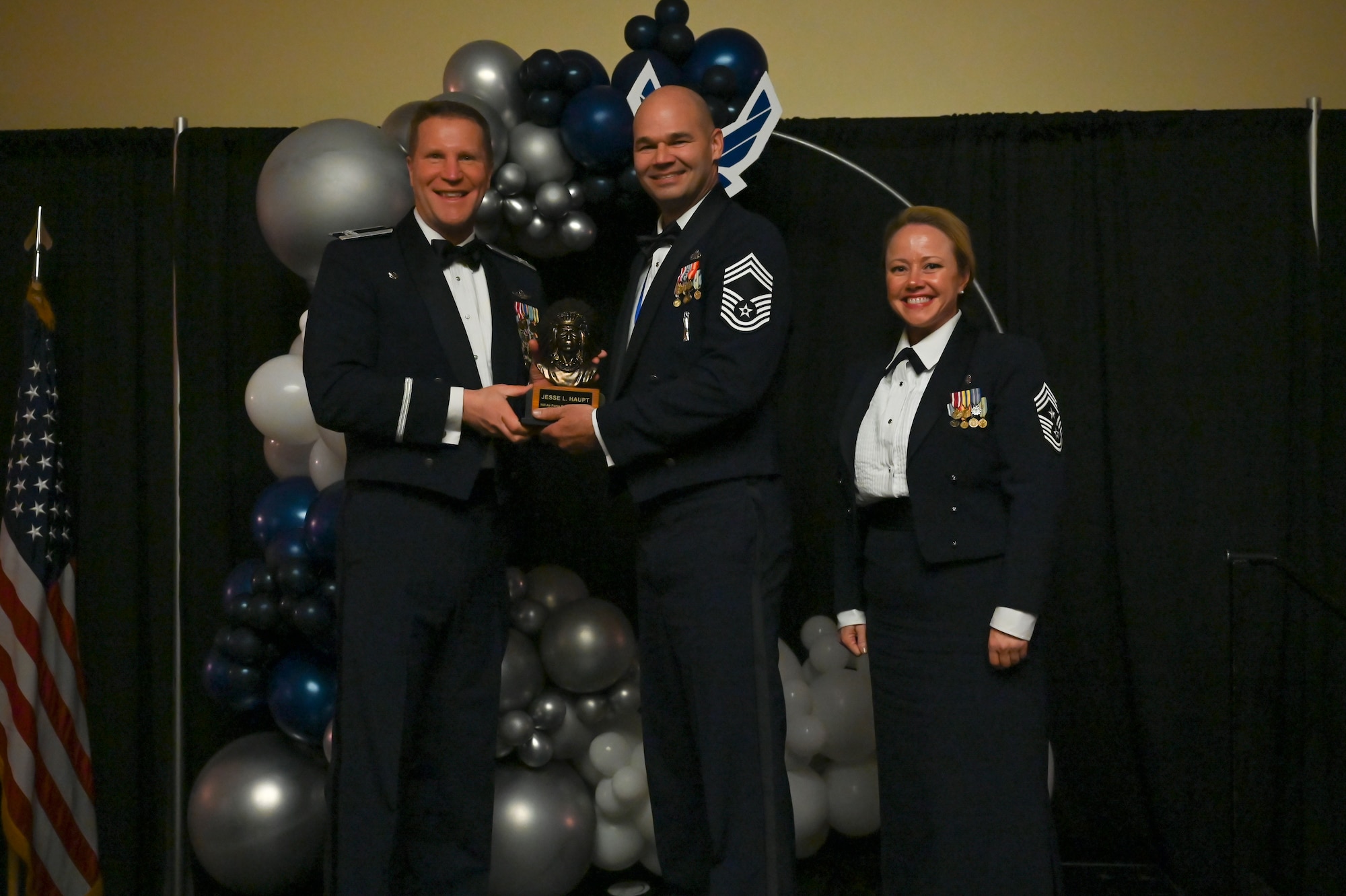 Chief Master Sgt. Jesse Haupt (center), 419th Maintenance Squadron, poses with Col. Matthew Fritz (left), 419th Fighter Wing commander, and Chief Master Sgt. Heather Richins, 419th FW command chief