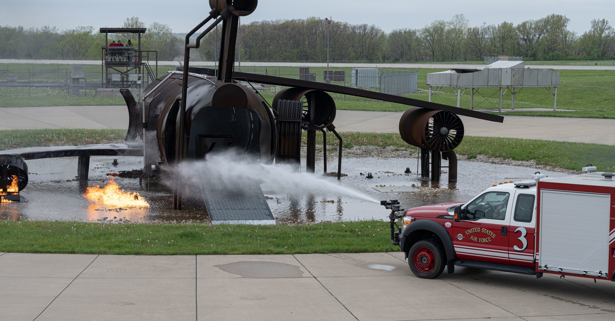 Fire protection specialists assigned to the 509th Civil Engineering Squadron conduct a training demonstration for a group of kindergarteners from Whiteman Elementary School during a base field trip on Whiteman Air Force Base, Missouri, May 4, 2022. The students toured various facilities on base receiving demonstrations from security forces and the fire department. (U.S. Air Force photo by Airman 1st Class Bryson Britt)