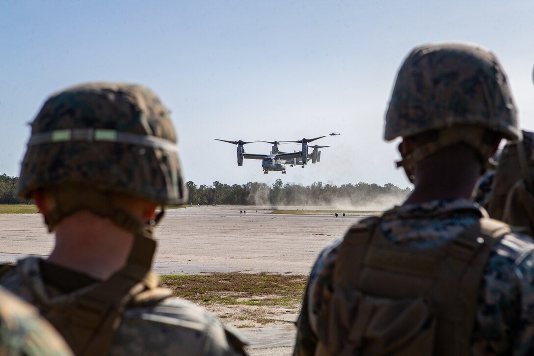 Marines with Marine Wing Support Squadron 271 observe MV-22B Ospreys land during a base repair after attack training (BRAAT) event at Marine Corps Outlying Field Oak Grove, North Carolina, Nov. 4, 2020. Marine Wing Support Squadron 271 (MWSS-271) partnered with Seabees with Naval Mobile Construction Battalion 1 to conduct a BRAAT in order to maintain readiness by demonstrating the ability to rapidly restore an airfield to operational capability following a simulated attack. The Marines and Seabees conducted an aerial insert into the training area via MV-22B Ospreys with Marine Medium Tiltrotor Squadron 263 (VMM-263). MWSS-271 and VMM-263 are subordinate units of 2nd Marine Aircraft Wing, which is the aviation combat element of II Marine Expeditionary Force. (U.S. Marine Corps photo by Lance Cpl. Elias Pimentel)